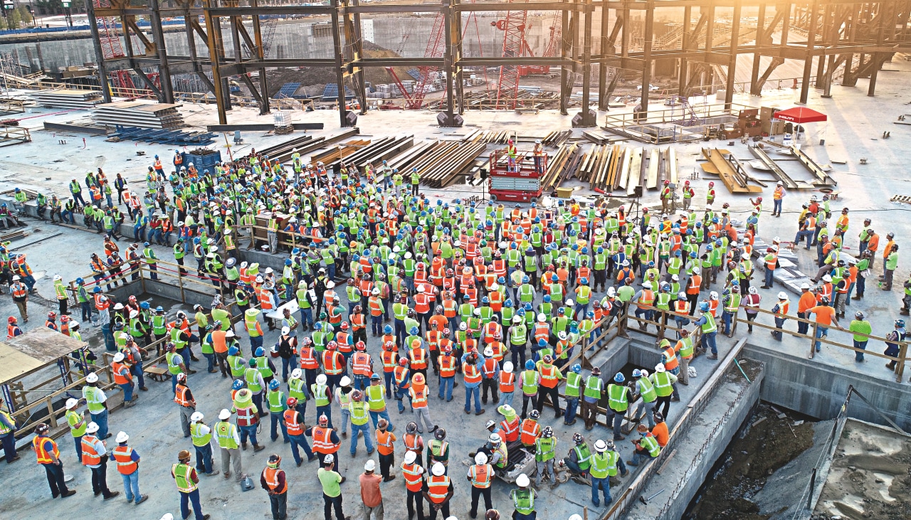 Drone picture of large group of construction workers on a site.